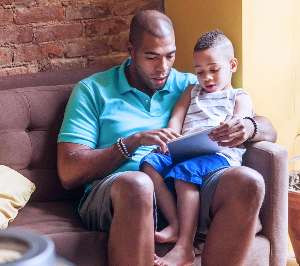 man and child looking at tablet