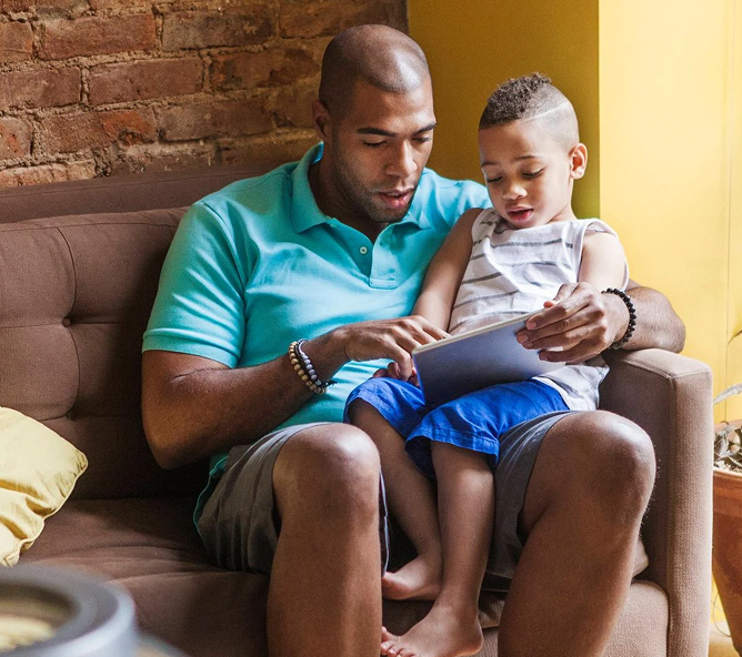 man and child looking at tablet